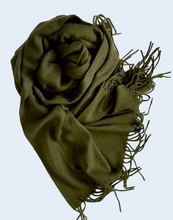 Load image into Gallery viewer, An army green knit scarf with fringed edges, artistically draped on a wrinkled white fabric background.
